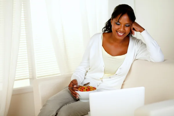 Mujer joven desayunando y usando laptop — Foto de Stock