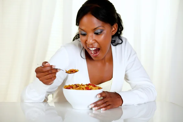 Surpreendida jovem mulher comendo uma tigela de cereais — Fotografia de Stock