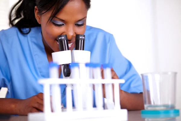 Afro-american scientific woman using a microscope — Stock Photo, Image