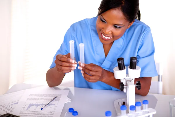 Lächelnde Wissenschaftlerin im Reagenzglas — Stockfoto