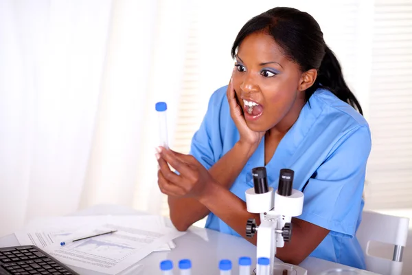 Surprised scientific woman looking to test tube — Stock Photo, Image