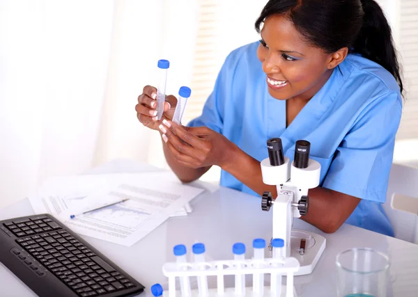 Satisfied scientific woman looking to test tube — Stock Photo, Image