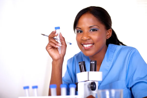 Scientific woman looking at you holding test tube — Stock Photo, Image