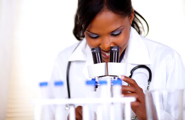 Женщина-врач работает с микроскопом — стоковое фото