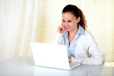 Beyaz genç kadın laptop ekranında okuma