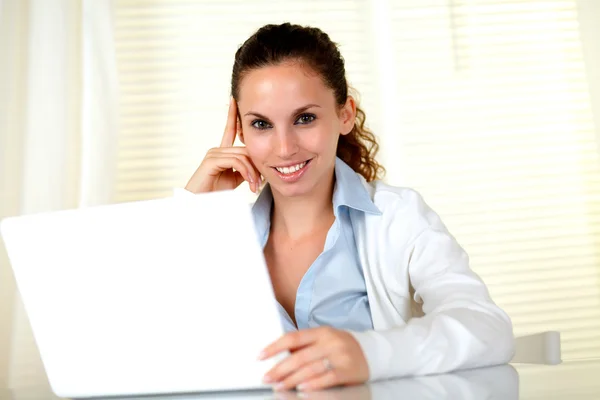 Sorrindo jovem mulher olhando para você com laptop — Fotografia de Stock