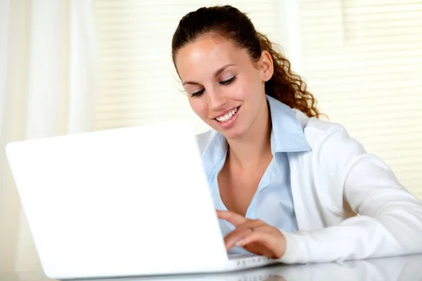 Smiling caucasian woman working on laptop Stock Photo