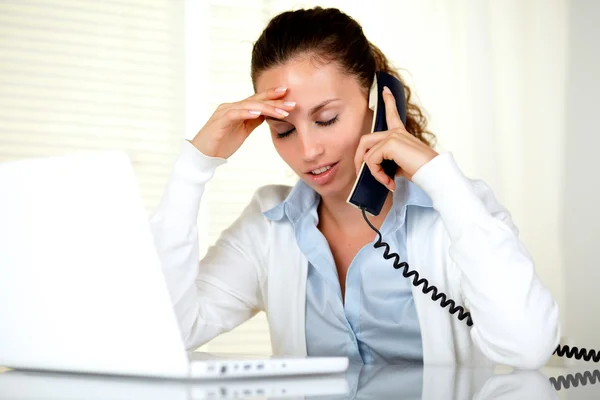 Stressed woman with headache speaking on phone — Stock Photo, Image