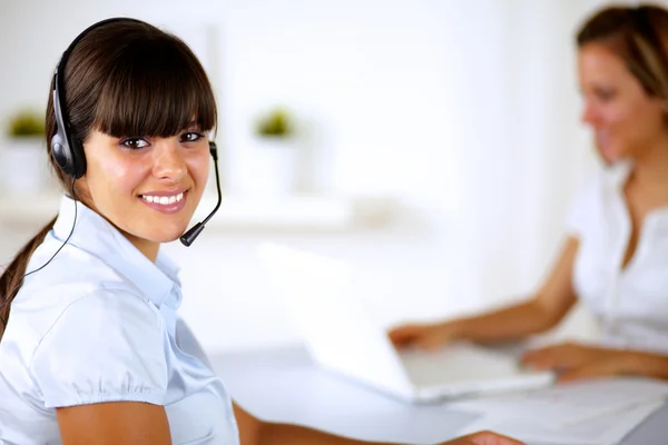 Mujer joven sonriente con auriculares trabajando —  Fotos de Stock