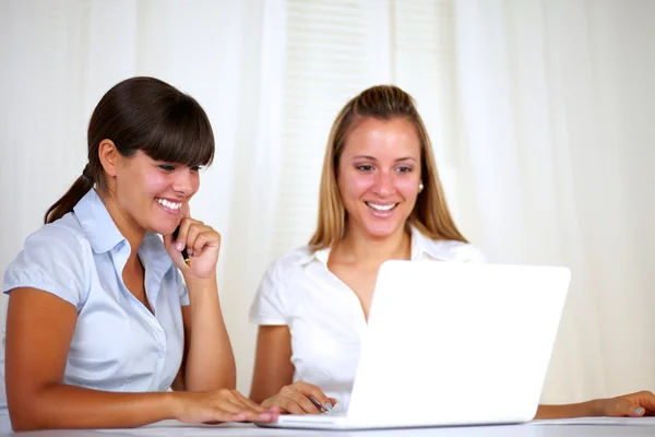 Donne lavoratrici sorridenti che leggono sullo schermo del computer portatile Foto Stock Royalty Free