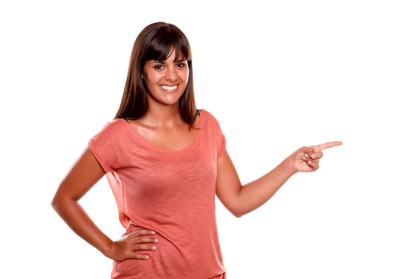 Stylish young woman looking at you pointing left — Stock Photo, Image