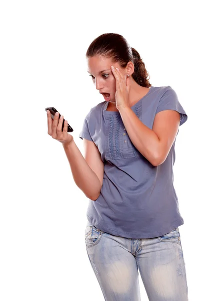 Mujer joven sorprendida leyendo en el teléfono celular —  Fotos de Stock