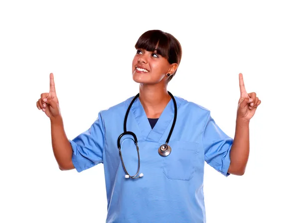 Smiling medical doctor woman pointing looking up — Stock Photo, Image