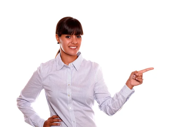 Smiling young woman pointing to her left — Stock Photo, Image