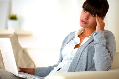 dizüstü bilgisayar kullanarak baş ağrısı olan büyüleyici kadın