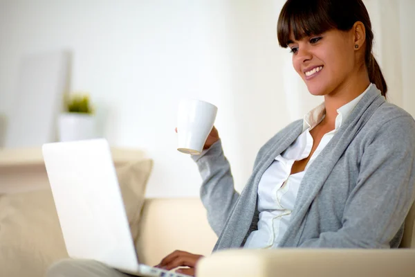 Mujer joven con una taza navegando por Internet — Foto de Stock