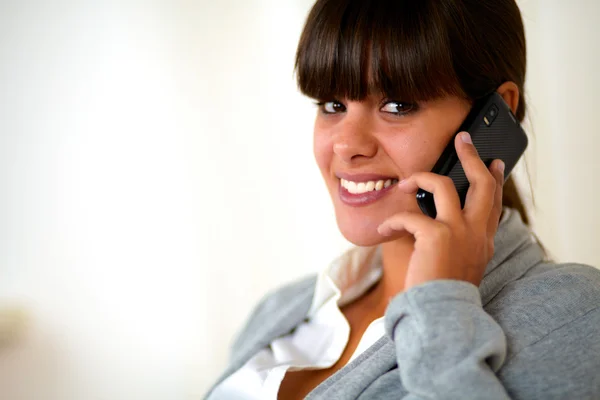 Ung kvinna tittar på dig tala på mobiltelefon — Stockfoto