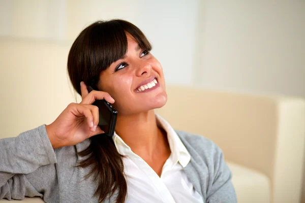 Mujer joven mirando hacia arriba hablando por teléfono celular — Foto de Stock