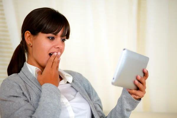 Mujer joven sorprendida leyendo la pantalla de la tableta PC — Foto de Stock