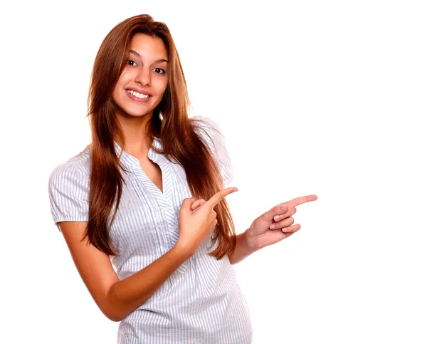 Smiling young woman pointing to her left — Stock Photo, Image