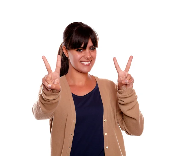 Mujer joven sonriendo y mostrándole señal de victoria —  Fotos de Stock