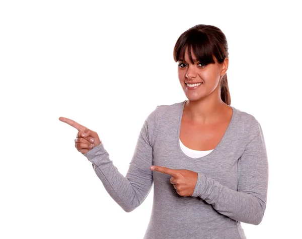 Smiling young woman with fringes pointing right — Stock Photo, Image