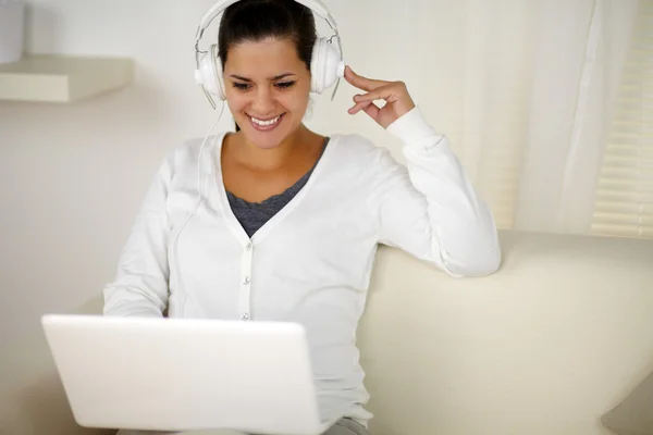 Charmig kvinna med hörlurar lyssnar musik — Stockfoto
