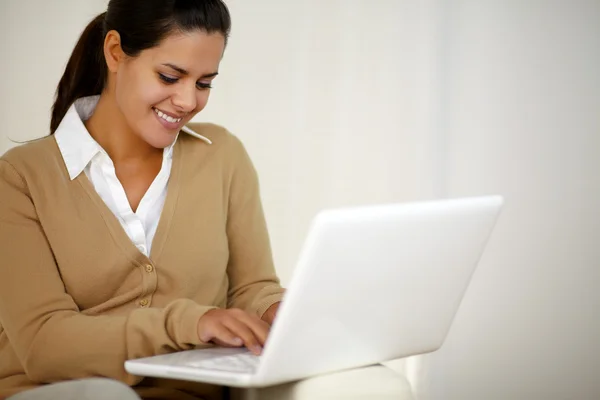 Mujer joven sonriente que trabaja con computadora portátil — Foto de Stock