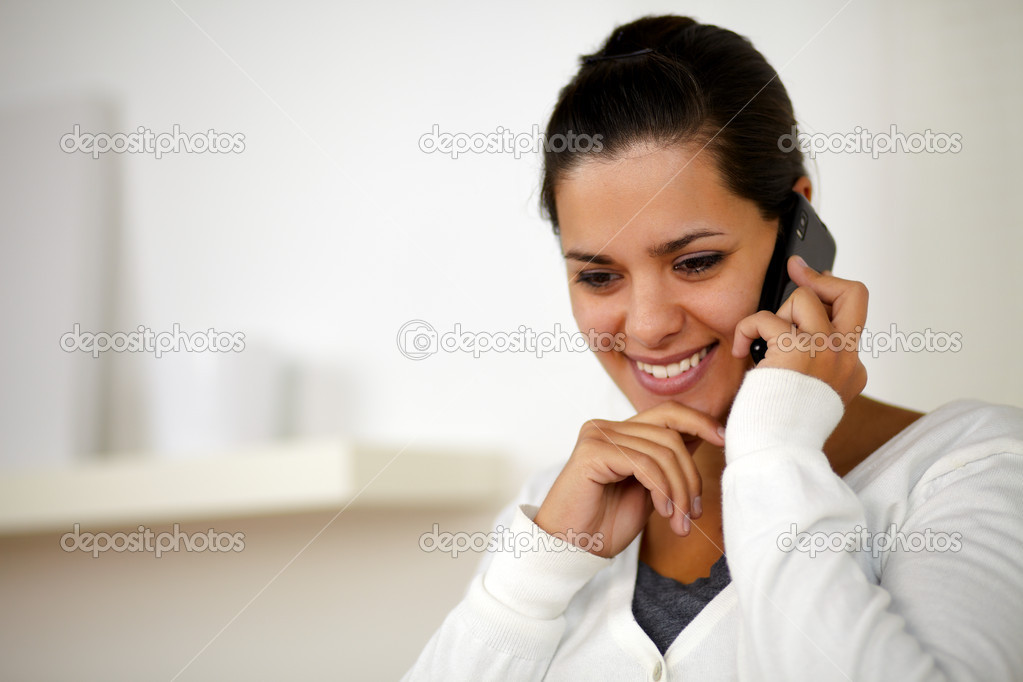 Pretty young woman conversing on cellphone