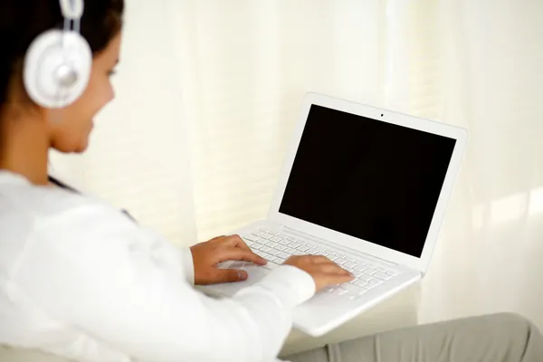 Jovem mulher trabalhando no laptop ouvir música — Fotografia de Stock