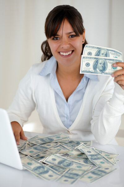 Young woman looking at you holding cash money