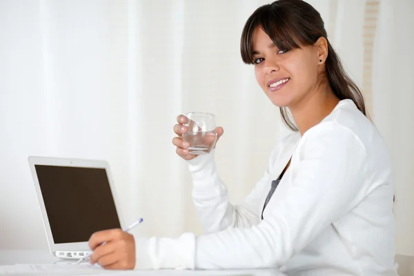 Jovem mulher bebendo água no escritório — Fotografia de Stock