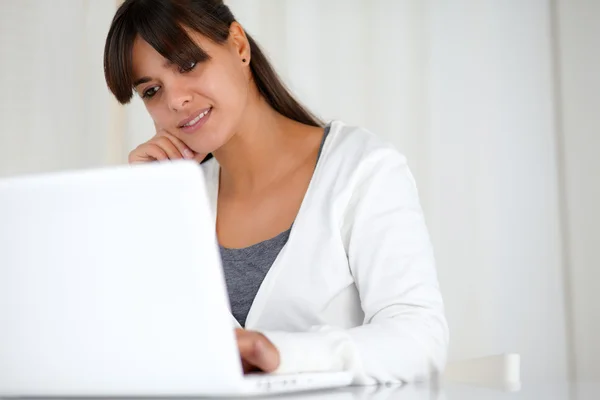 Hübsche junge Frau liest den Laptop-Bildschirm — Stockfoto