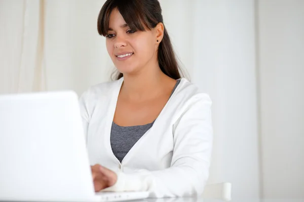 Pretty young woman browsing the internet on laptop — Stock Photo, Image