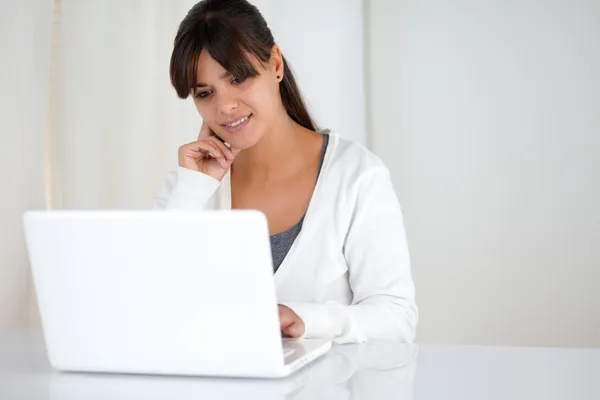 Encantadora joven mujer leyendo la pantalla del ordenador portátil —  Fotos de Stock