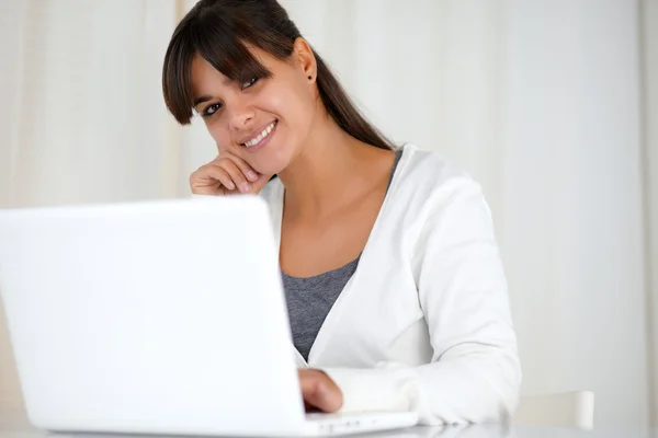Lachende jonge vrouw op zoek naar jou met behulp van laptop — Stockfoto