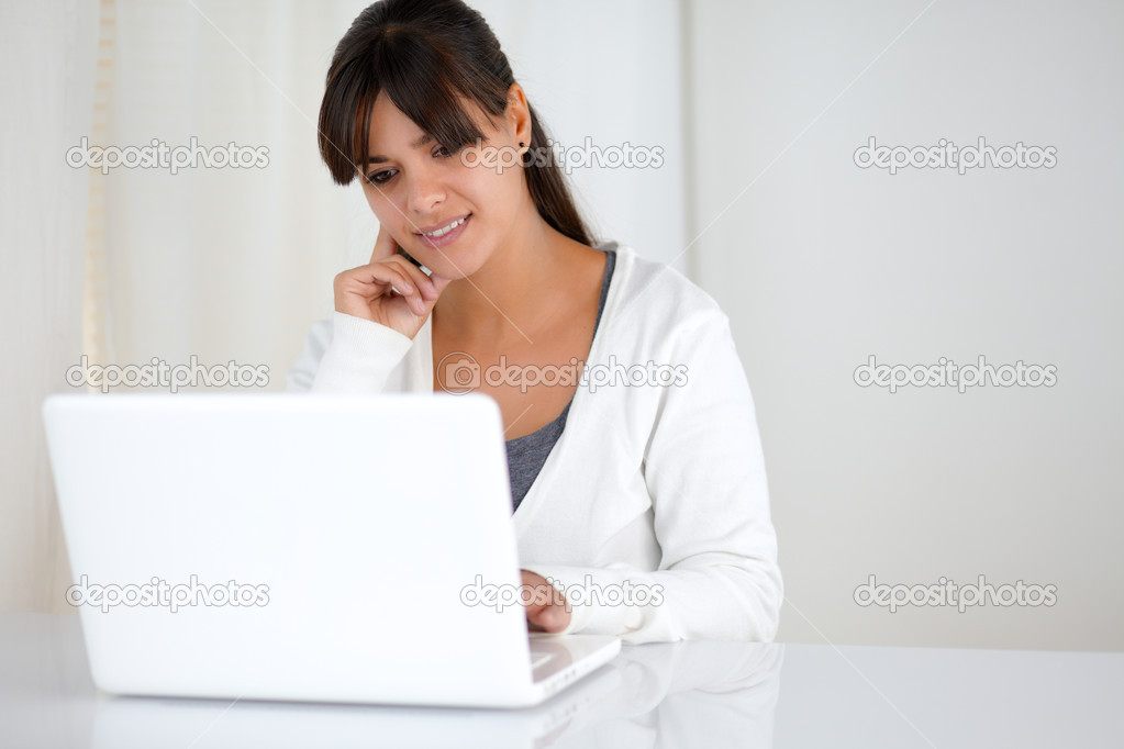 Charming young female reading the laptop screen