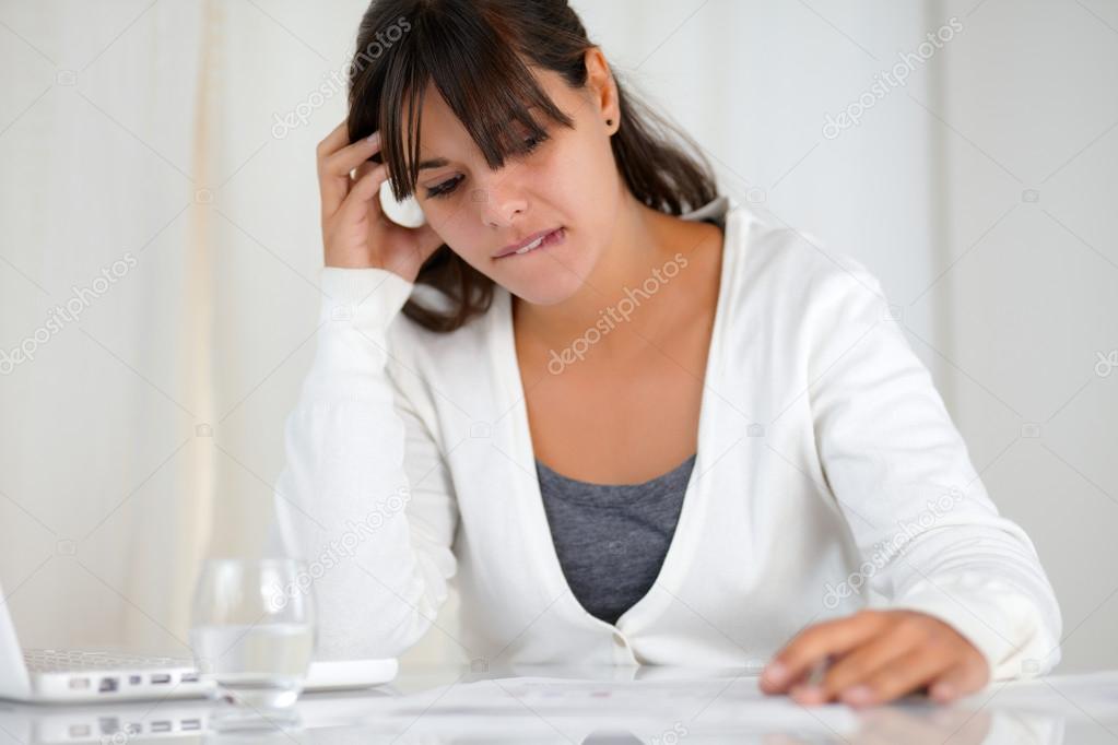 Stressed young woman working in front of laptop
