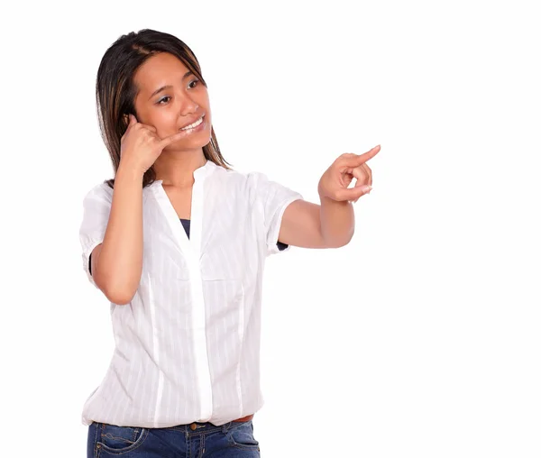 Young woman saying call me pointing to her left — Stock Photo, Image