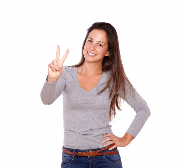 Gülümseyen kadın parmaklarını zafer işaretiyle gösterilen — Stok fotoğraf
