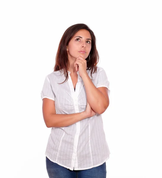 Reflective pretty young woman in jeans looking up — Stock Photo, Image