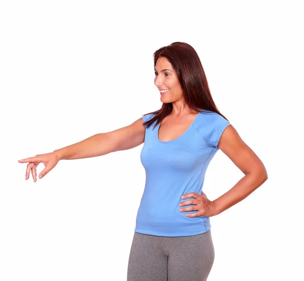 Sporty senior woman in gym clothing pointing right — Stock Photo, Image