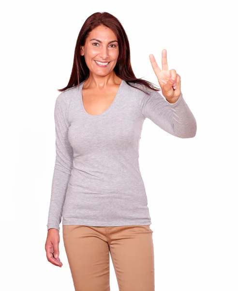 Lovely woman gesturing victory sign with fingers — Stock Photo, Image