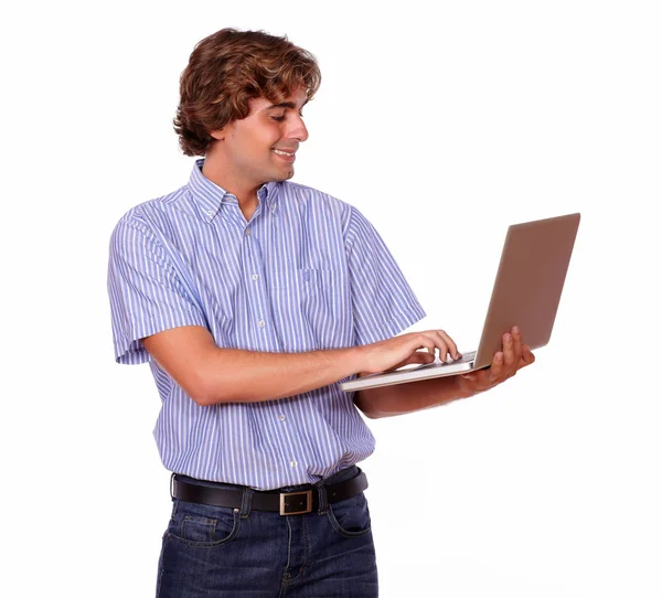 Schöner Mann lächelt, während er am Laptop arbeitet. — Stockfoto