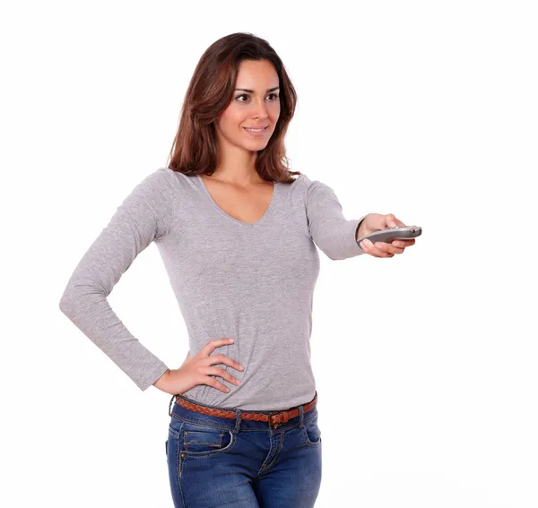 Charming woman pointing the remote while standing — Stock Photo, Image