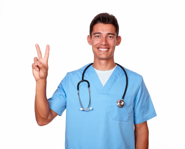 Hombre carismático en uniforme de enfermera haciendo gestos de victoria —  Fotos de Stock