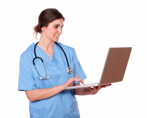Encantadora enfermeira com estetoscópio usando um laptop — Fotografia de Stock