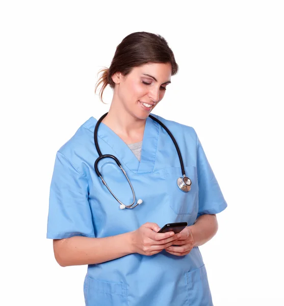 Enfermera encantadora sonriendo mientras envía un mensaje — Foto de Stock
