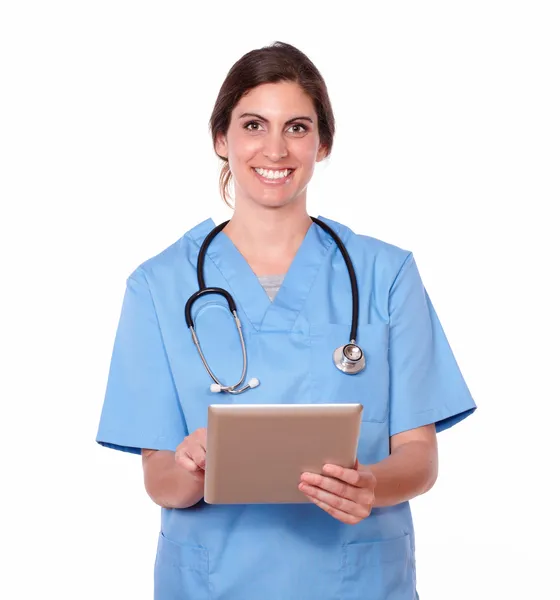 Smiling pretty lady nurse working on tablet pc Stock Picture