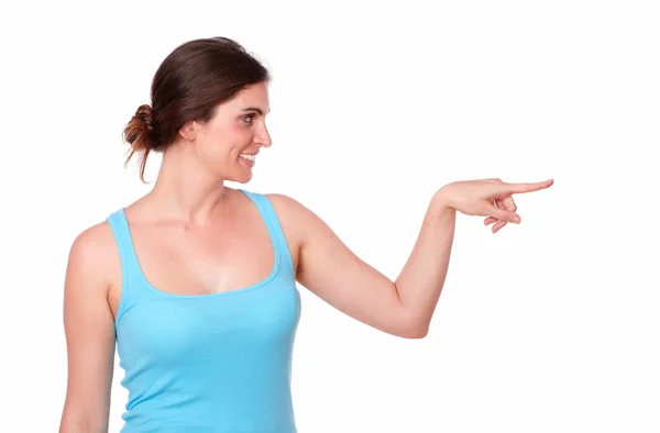 Passar ung kvinna som pekar på hennes vänstra — Stockfoto